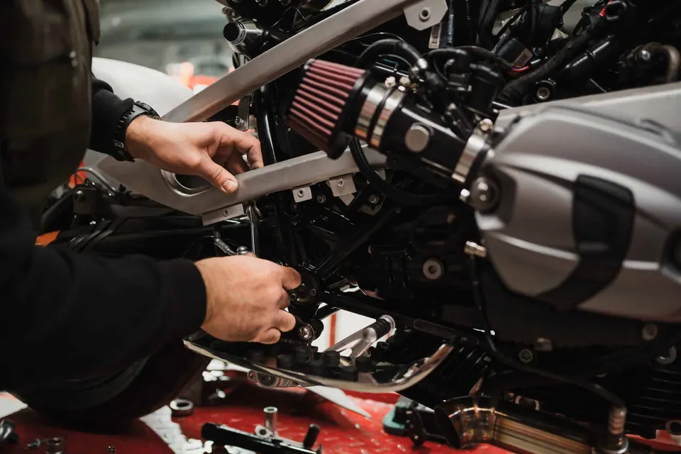 Mécanicien réparant une moto dans un atelier moderne
