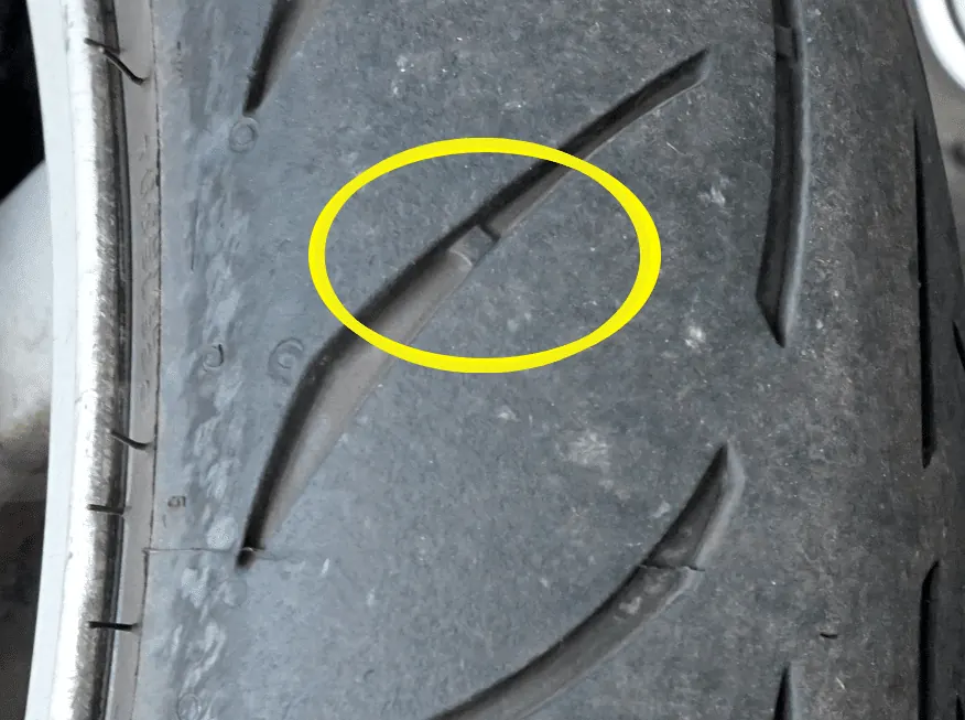 Témoin d’usure d’un pneu de moto entouré en jaune